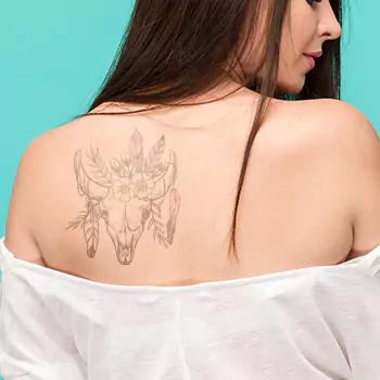 Bull skull tattoo with flowers design thigh, chest, and back
