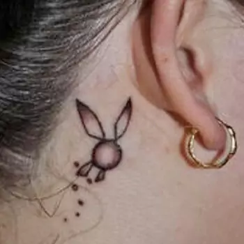 Playboy bunny tattoo behind the ears